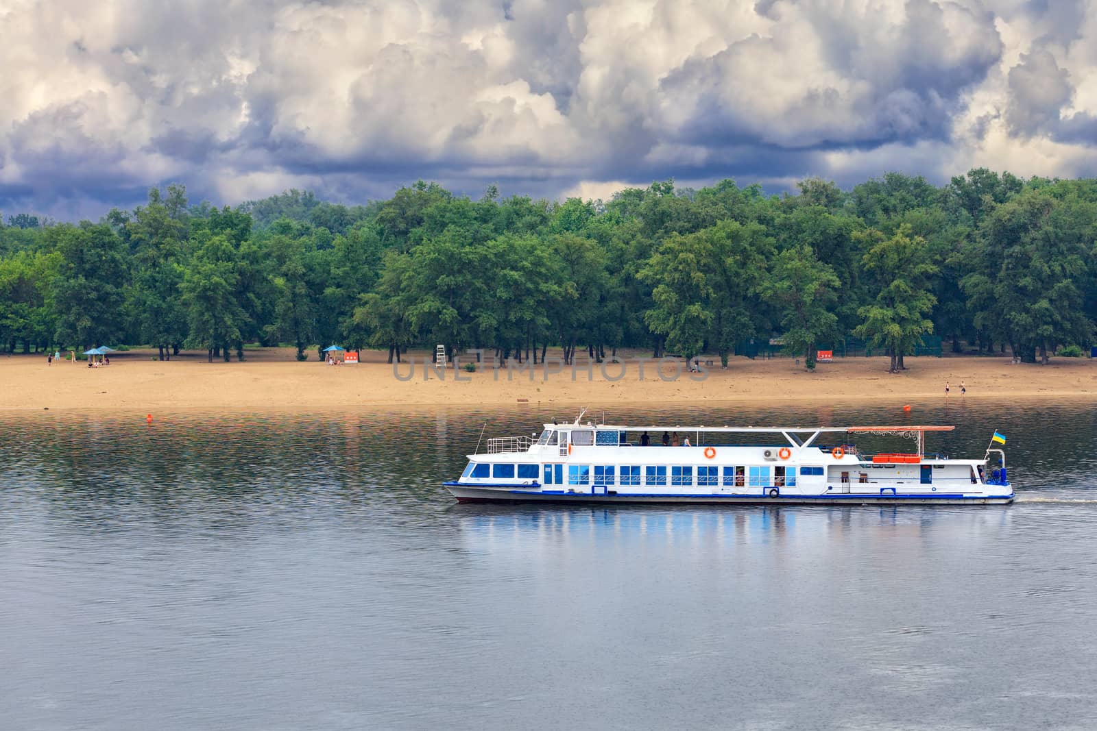 A river tram runs along the banks of the Dnipro against the backdrop of a deserted beach in anticipation of an impending thunderstorm. by Sergii