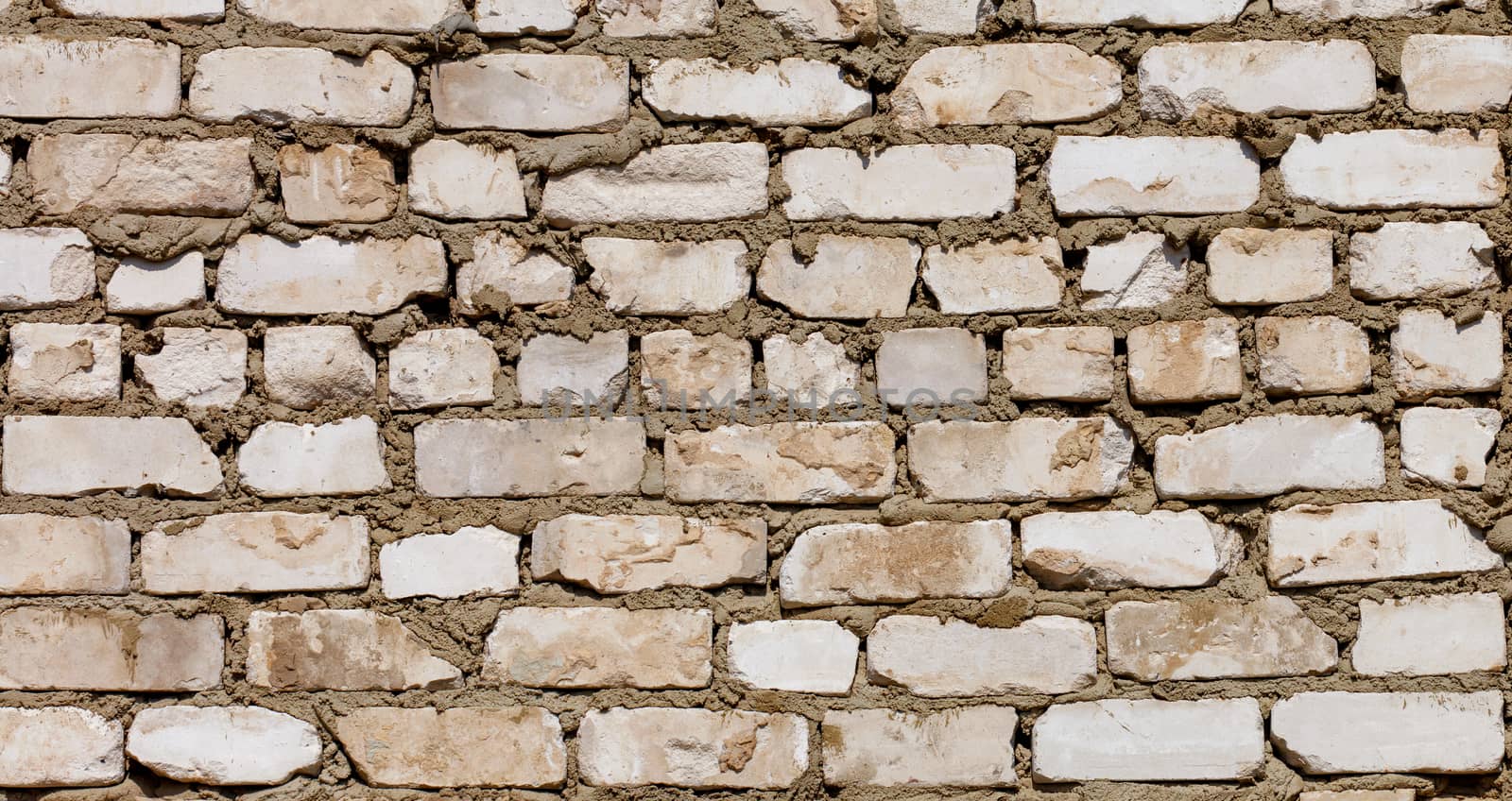 Wall texture of white old brick and cement mortar, close-up. by Sergii