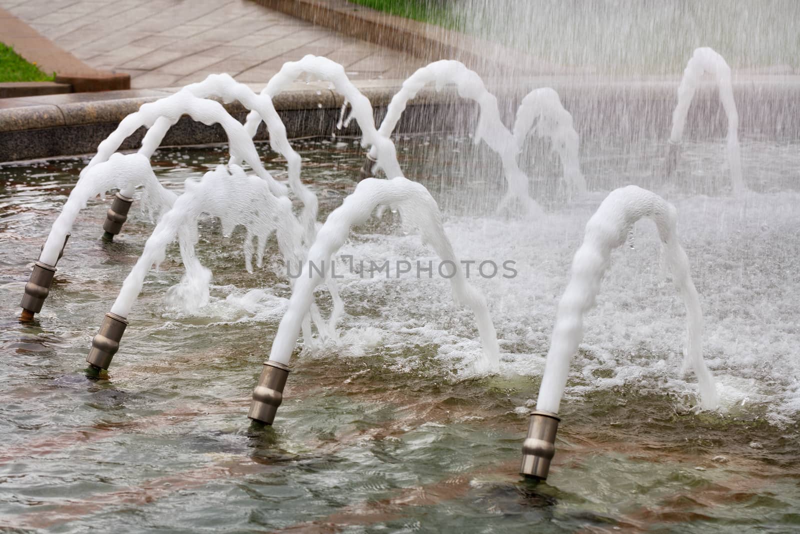 In the city fountain, metal cannons create a beautiful water carousel of foaming jets of water that powerfully burst to the surface.