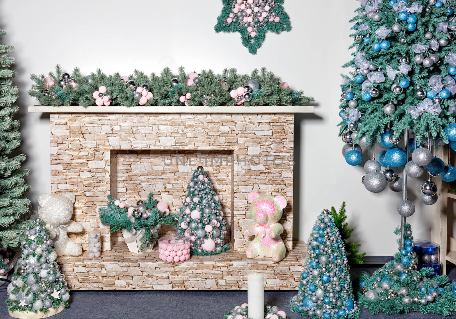 New Years holiday, fireplace with gifts, decorative Christmas trees, toys, balls and fir branches. by Sergii