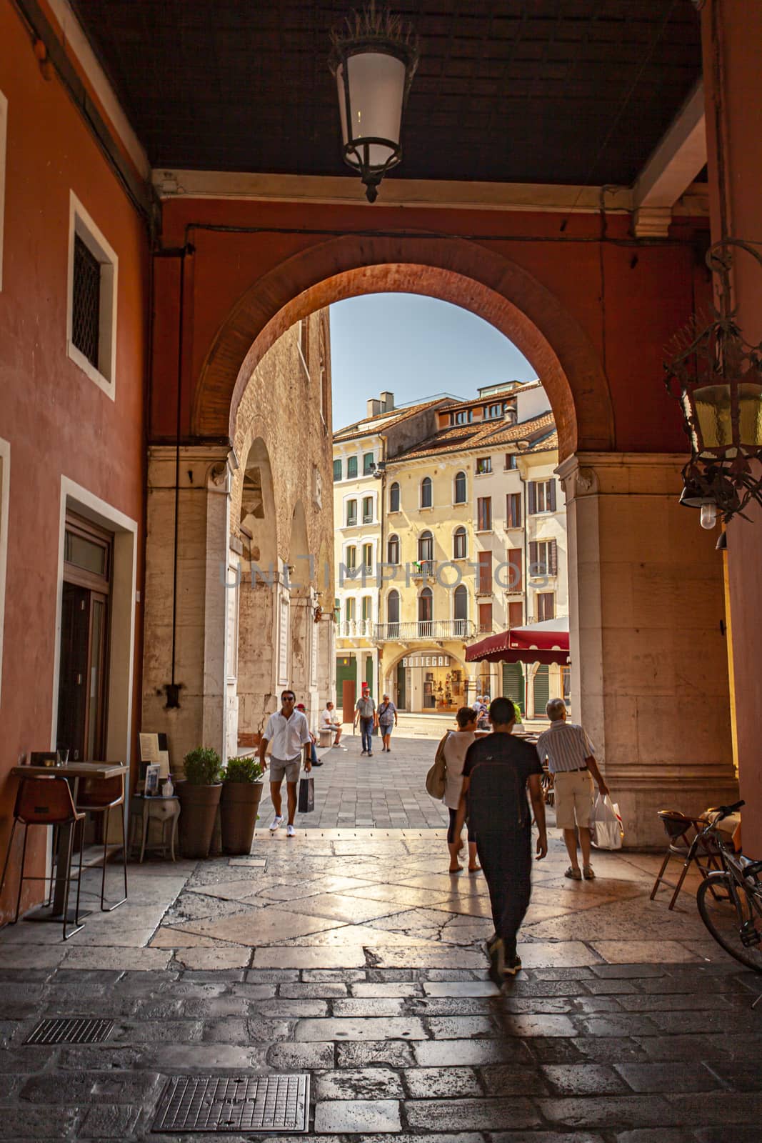 TREVISO, ITALY 13 AUGUST 2020: Arcades in Piazza dei signori in Treviso with people passing through