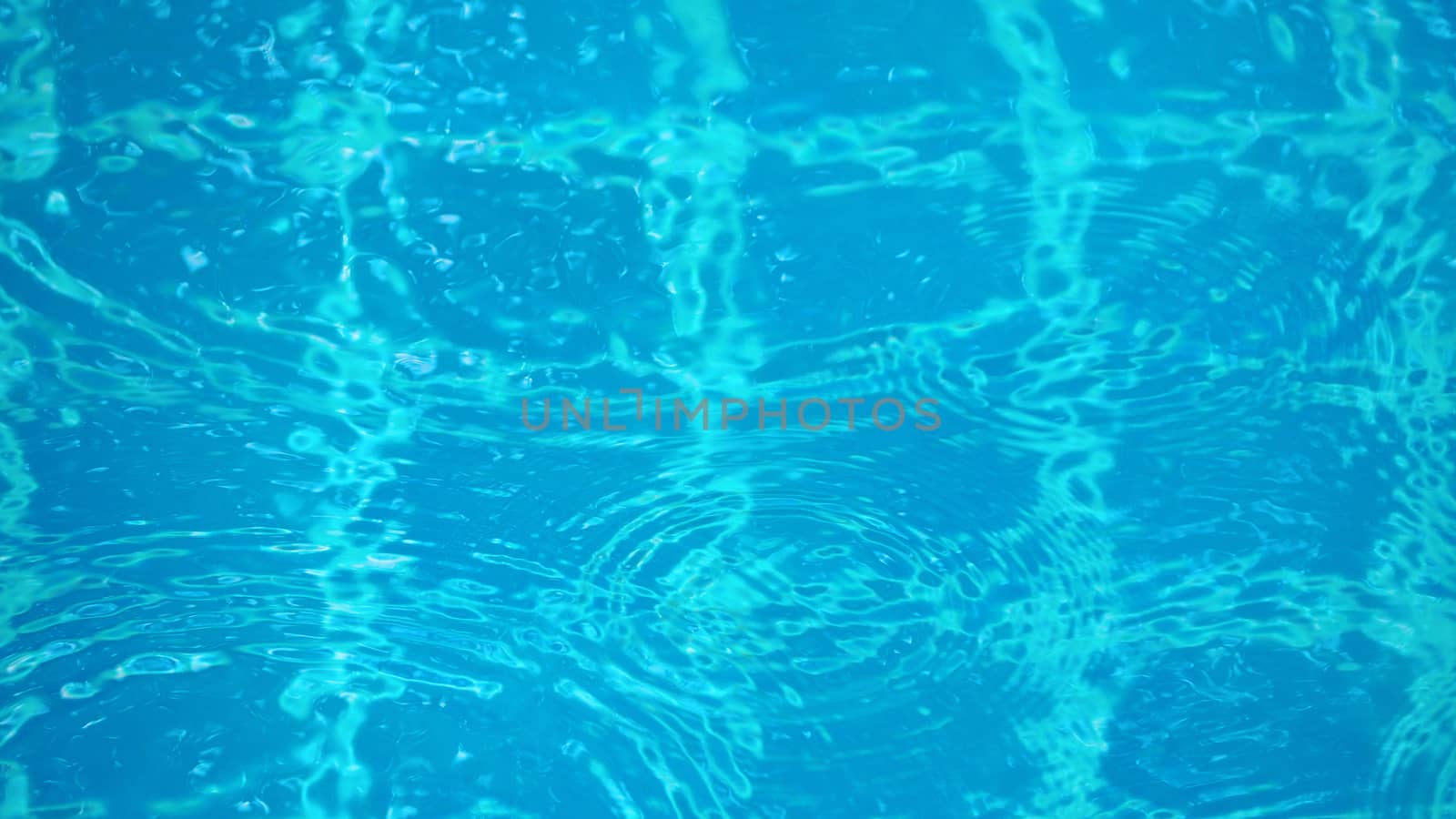 Rain drop falling on pool and have ripple shape and sun light reflection on surface for abstract background. 