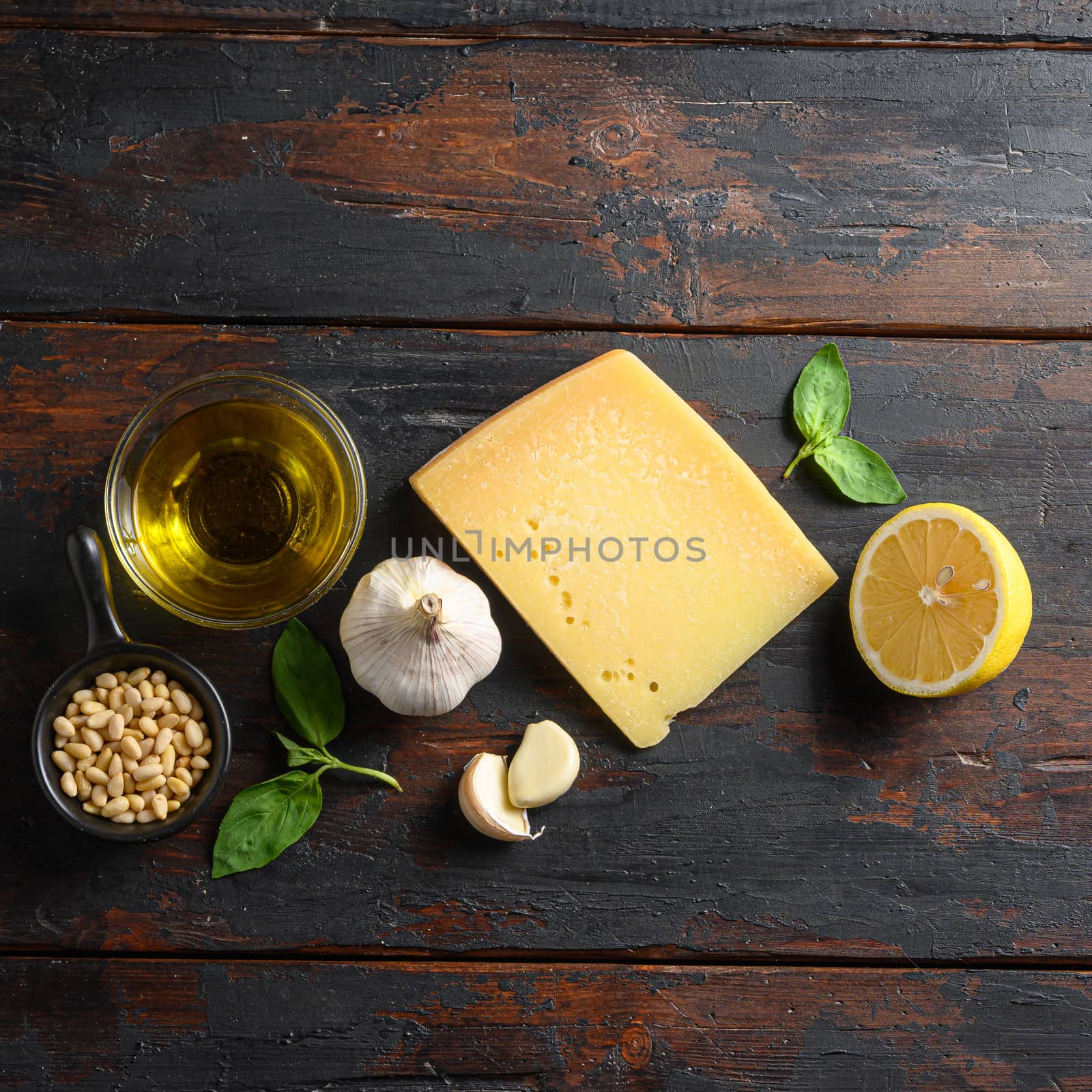 Green basil pesto italian recipe Preparing Parmesan cheese, basil leaves, pine nuts, olive oil, garlic, salt and pepper. on wooden table top view square by Ilianesolenyi