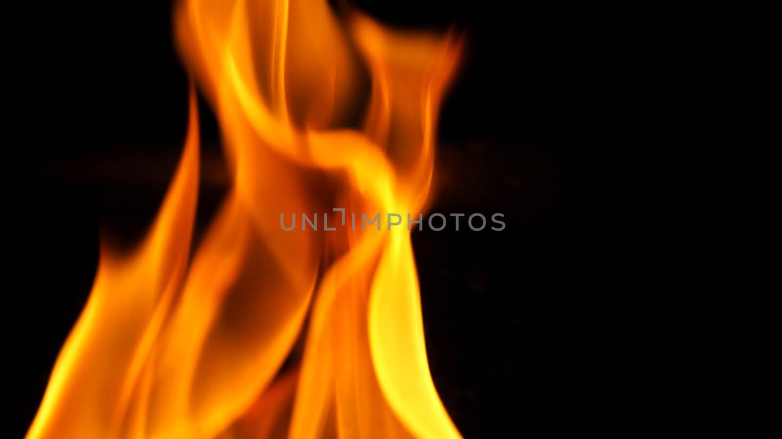 Fire blazing while cooking on black color background and close-up shot.