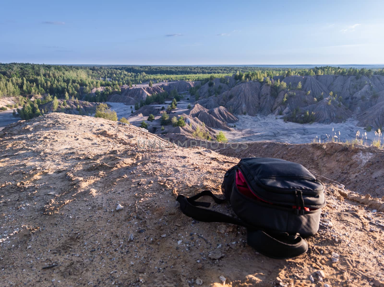 professional camera and photo backpack on top of the hill at summer daytime.
