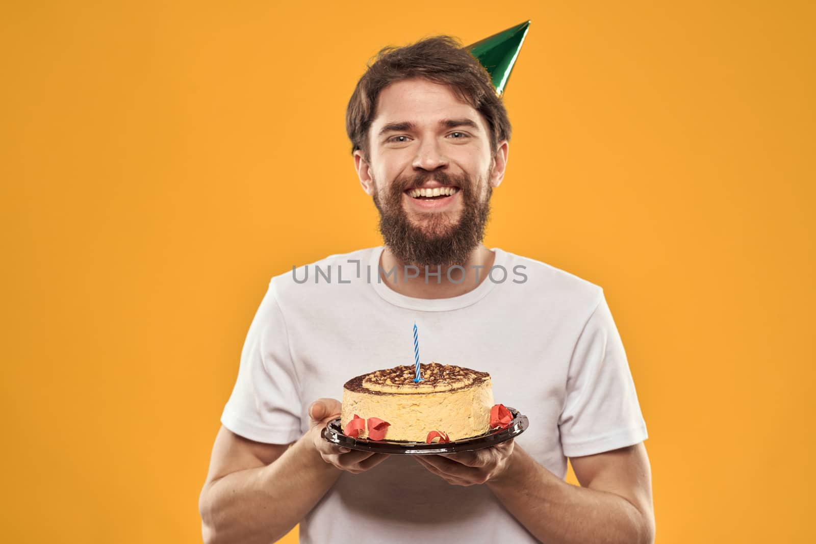 birthday boy in a cap with cake fun yellow background party by SHOTPRIME