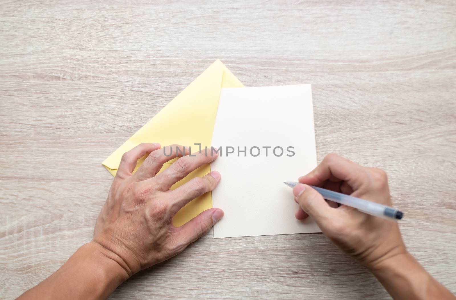 Male hands writing Empty cards on wooden table.