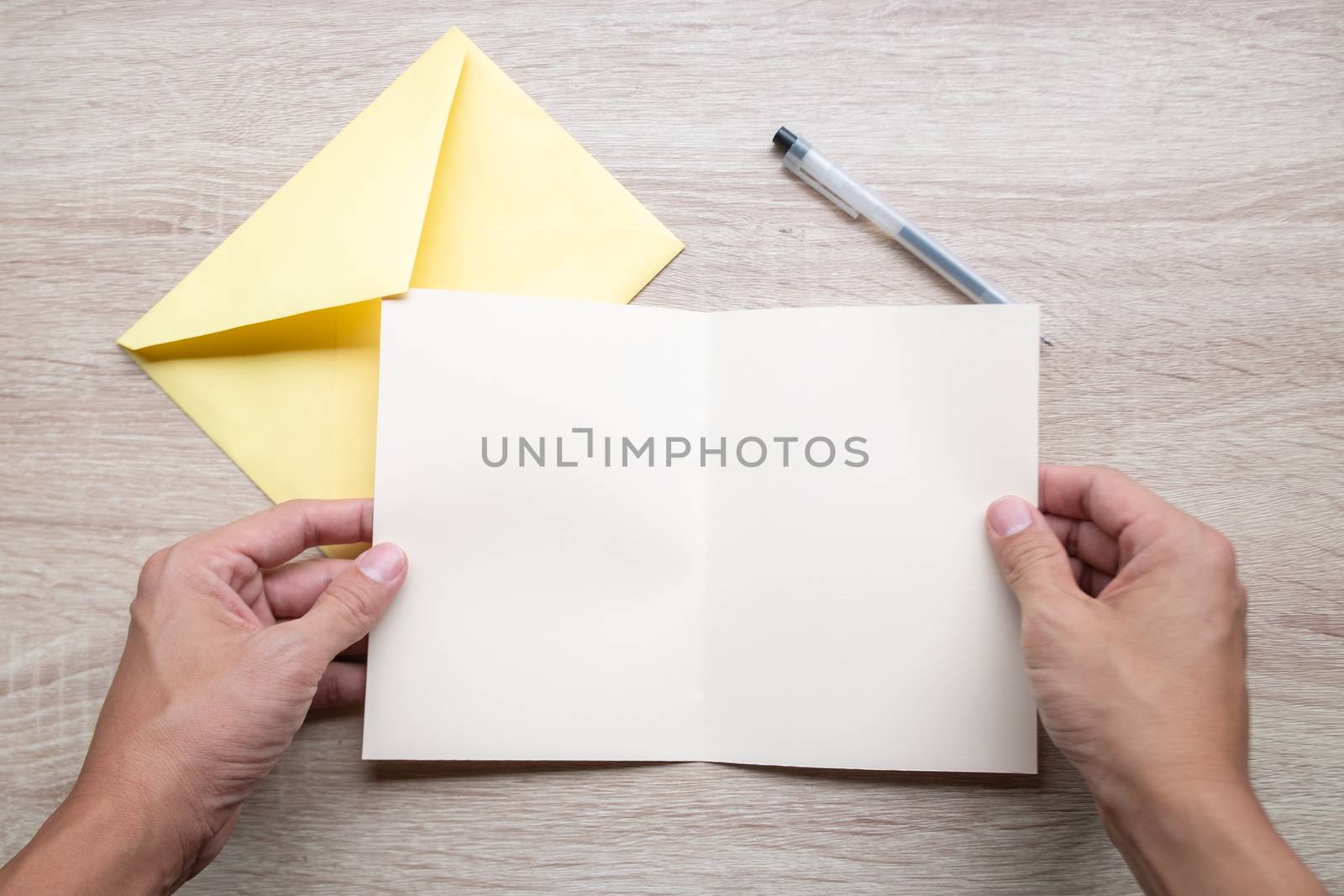 Male hands writing Empty cards on wooden table.