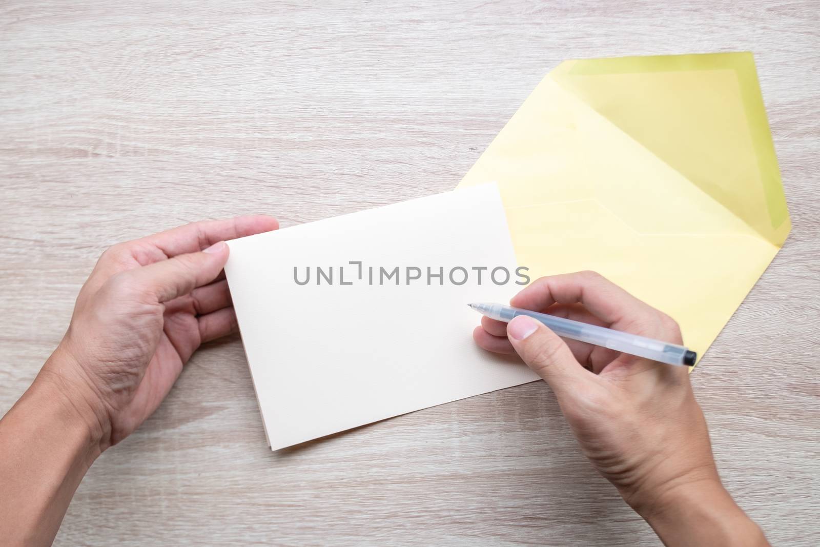 Male hands writing Empty cards on wooden table.