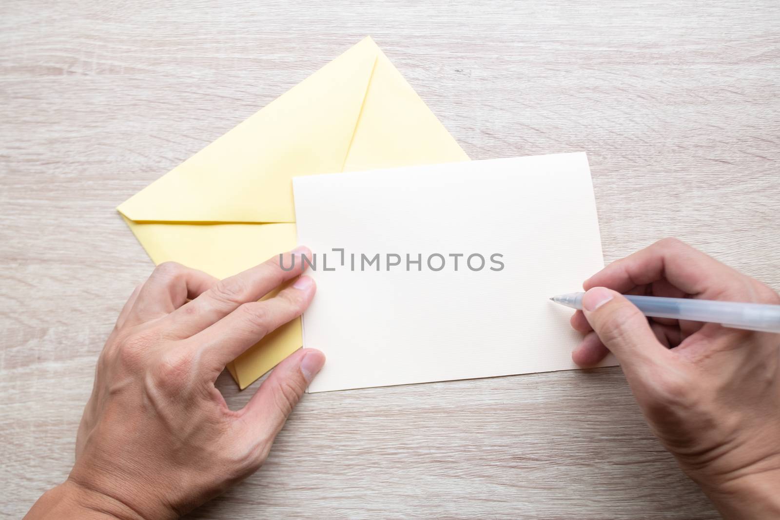 Male hands writing Empty cards on wooden table.