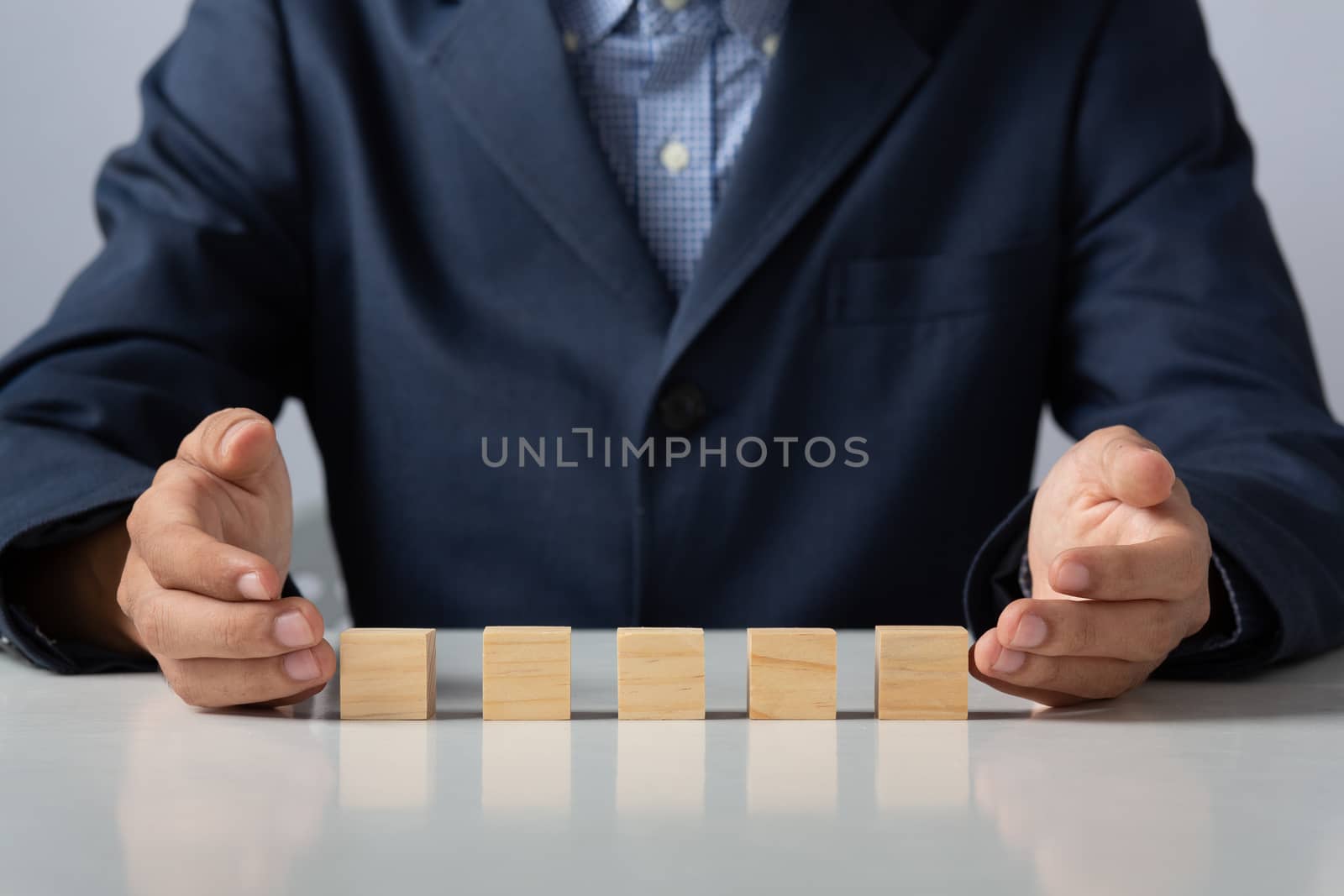 Hands of entrepreneur business man holding wooden blocks placing by golfmhee