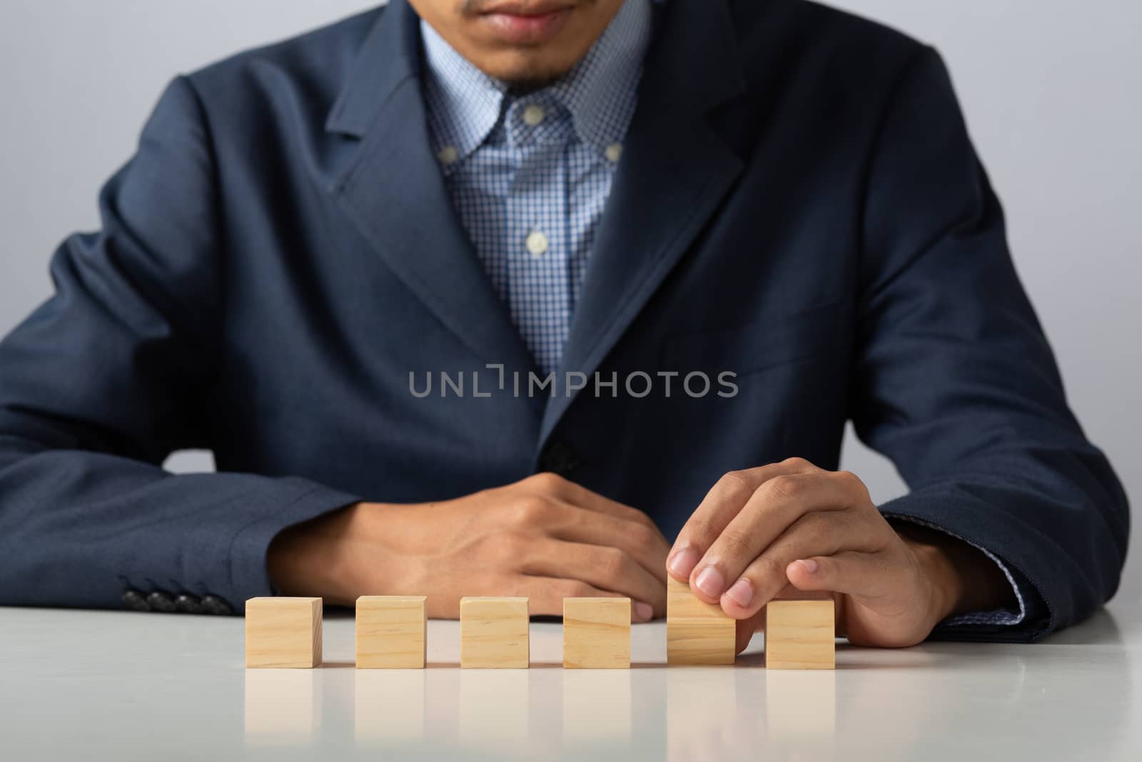 Hands of entrepreneur business man holding wooden blocks placing by golfmhee