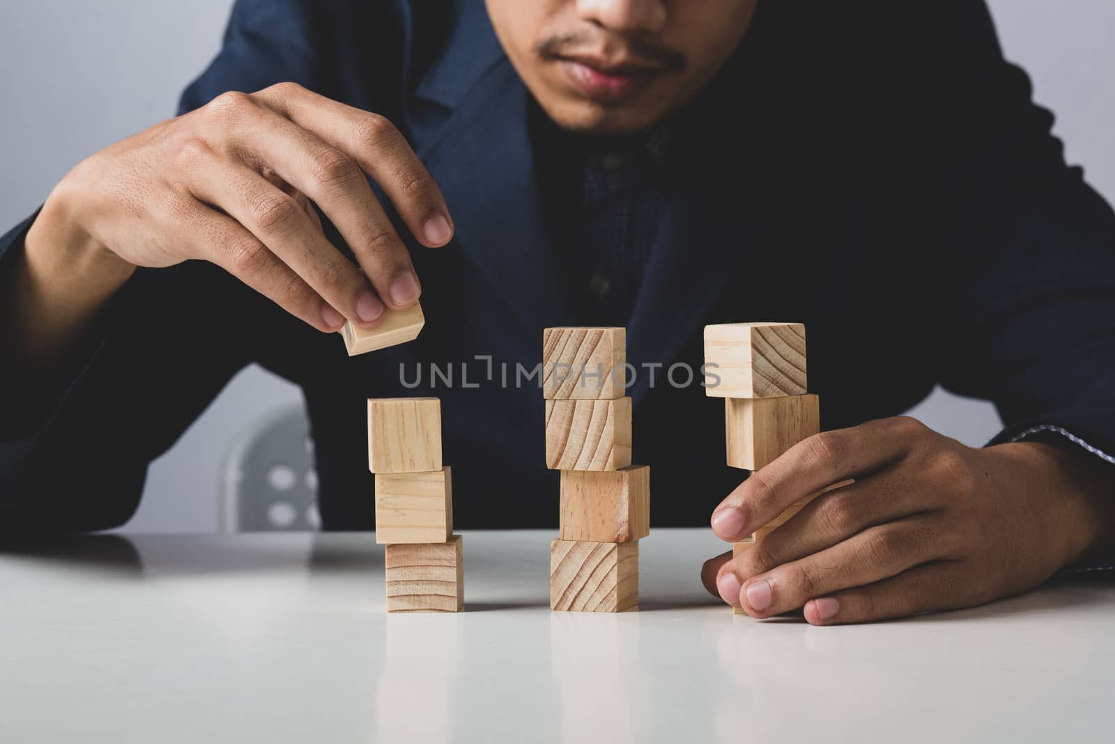 Hands of entrepreneur business man holding wooden blocks placing by golfmhee