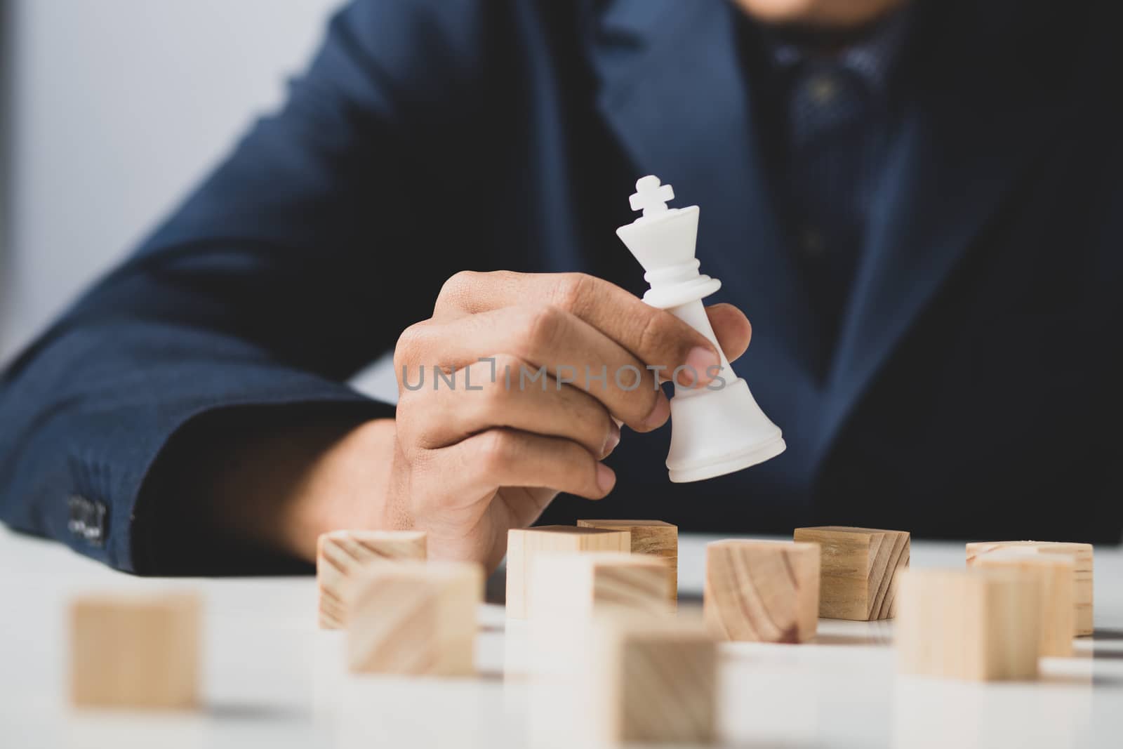 Hands of entrepreneur business man holding wooden blocks placing to a structure, Concept of teamwork, strategy, professional manager work for executive investor to corporate wealth of fundamental.