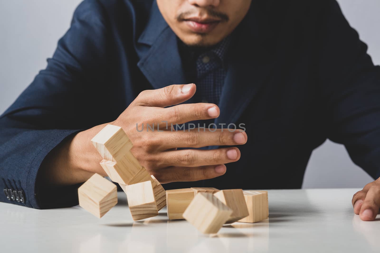 Hands of entrepreneur business man holding wooden blocks placing to a structure, Concept of teamwork, strategy, professional manager work for executive investor to corporate wealth of fundamental.