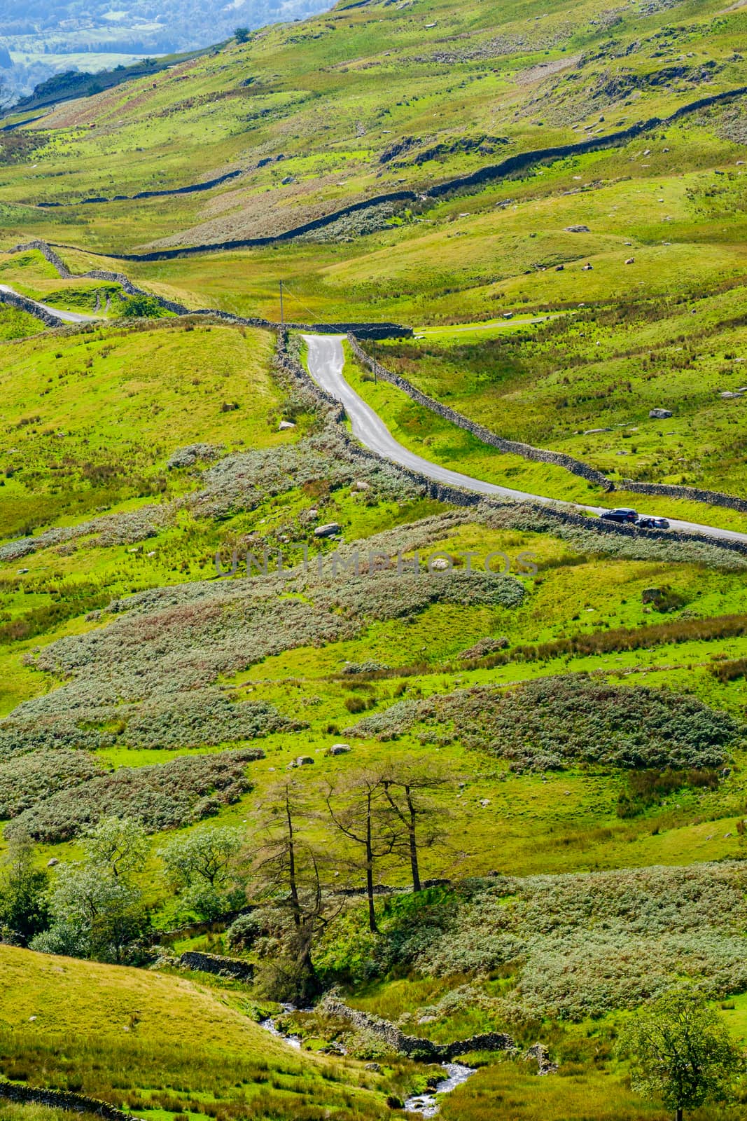 The Struggle road at Kirkstone Pass leading to Windermere lake Ambleside with Snarker Pike of Red Screes mountain on right in Lake District England