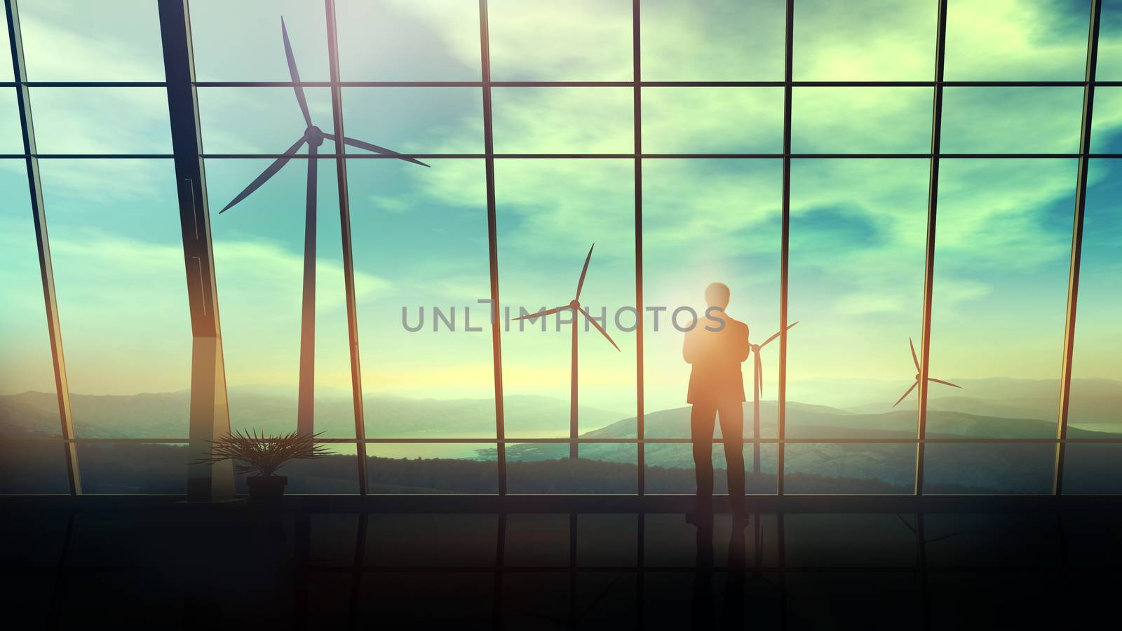 A silhouette of a businessman is standing against an office window overlooking the wind turbines.