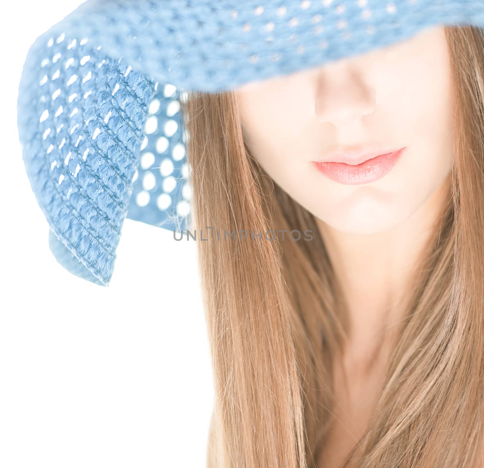 Portrait of pretty girl with her eyes under blue crocheted hat isolated on white background. Half hidden beautiful face. Woman beauty and mystery. Shy and modest.