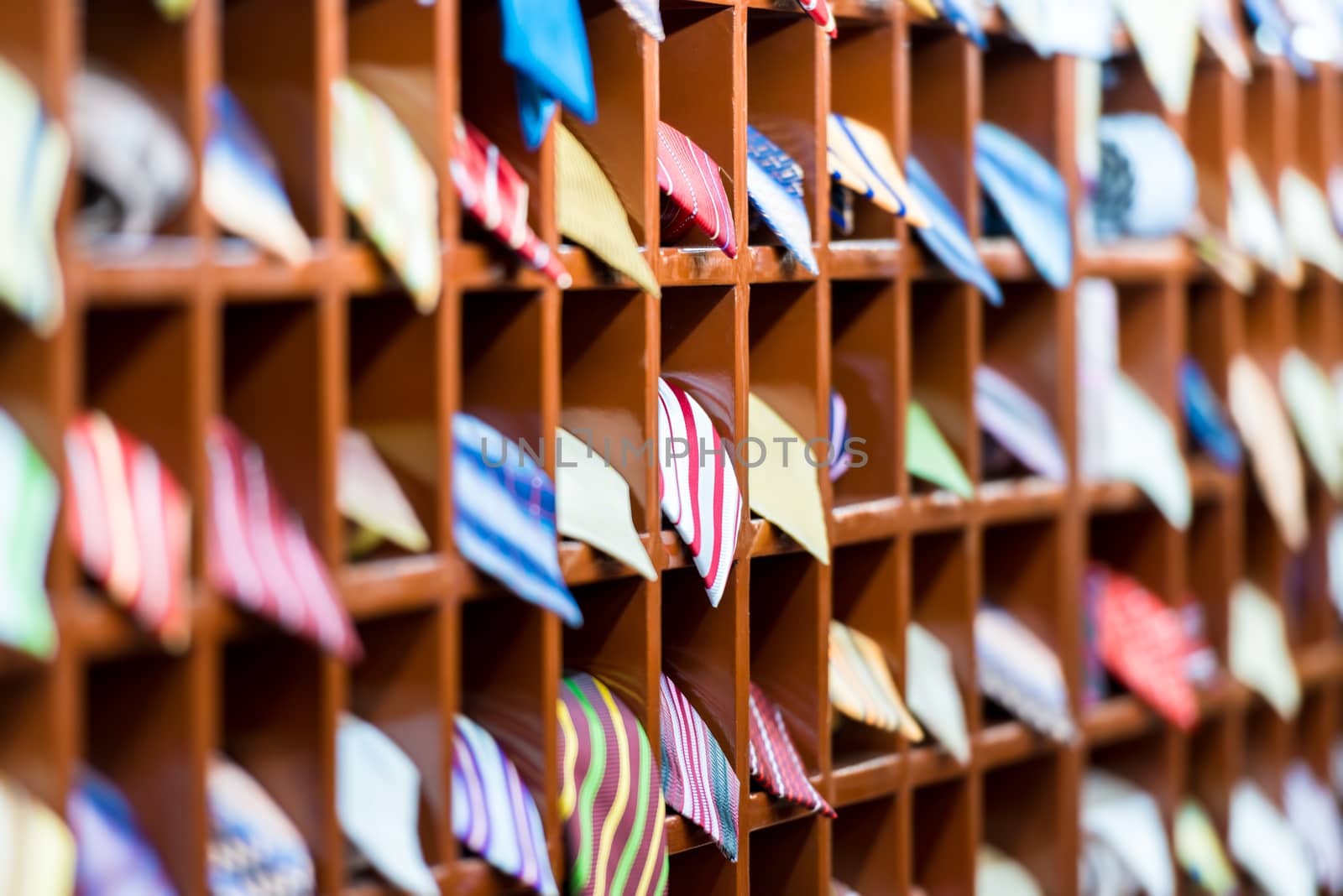 Rows of new colorful ties on shelves at shop. Great section of ties in different colors. Big choice of apparel or business style accessories ready for sale. Going shopping. Trade and commerce.