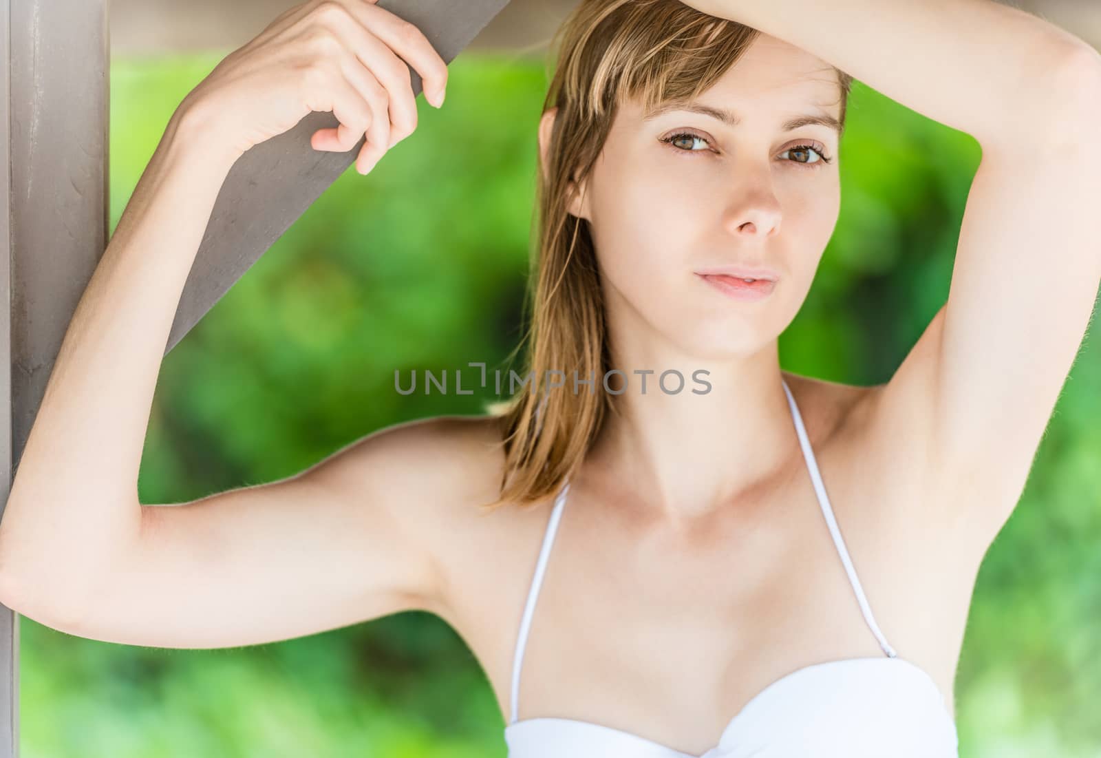 Beautiful young woman under wooden pier on beach. by Yolshin