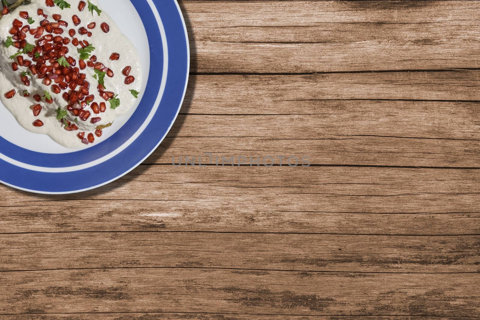 Top view of chiles en nogada, traditional festive dish on Mexican Independence Day. Green chili peppers with walnut sauce, common food for Mexico, in celebrations and national holidays. Copy Space