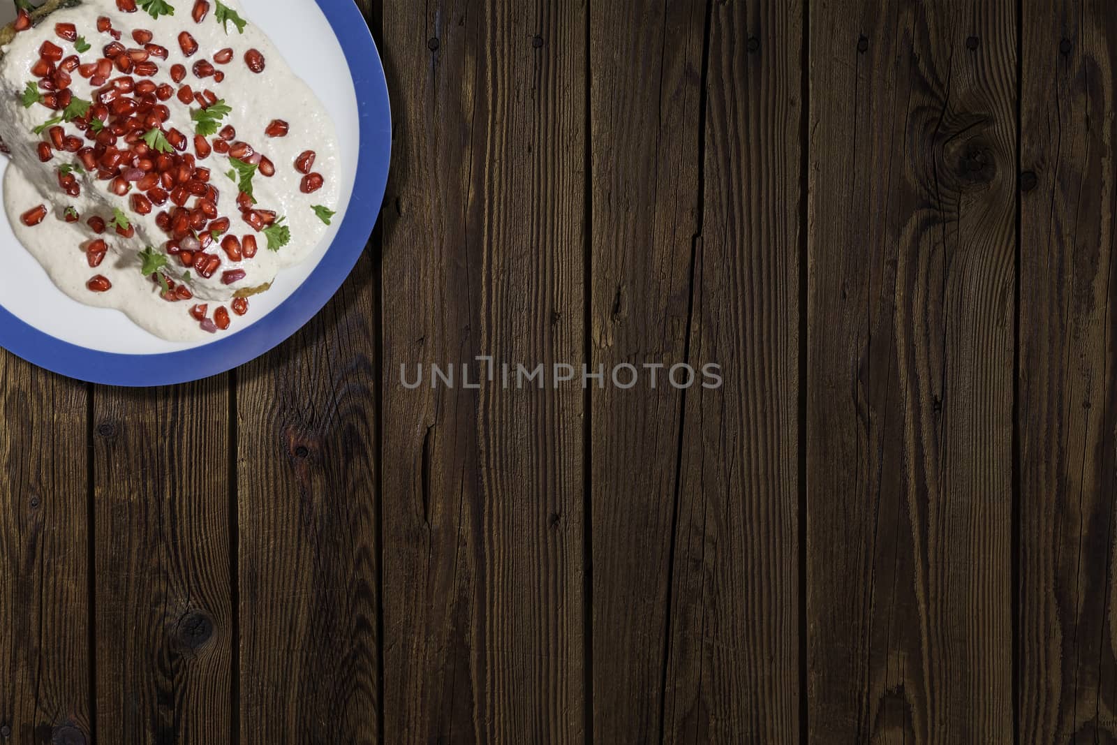 Top view of chiles en nogada, traditional festive dish on Mexican Independence Day. Green chili peppers with walnut sauce, common food for Mexico, in celebrations and national holidays. Copy Space