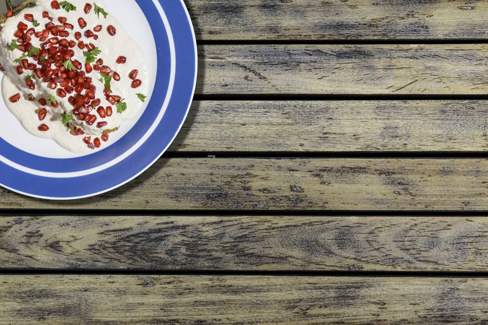 Top view of chiles en nogada, traditional festive dish on Mexican Independence Day. Green chili peppers with walnut sauce, common food for Mexico, in celebrations and national holidays. Copy Space