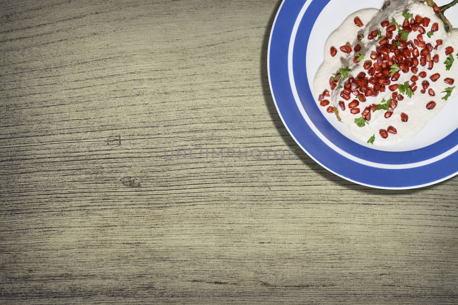 Top view of chiles en nogada, traditional festive dish on Mexican Independence Day. Green chili peppers with walnut sauce, common food for Mexico, in celebrations and national holidays. Copy Space