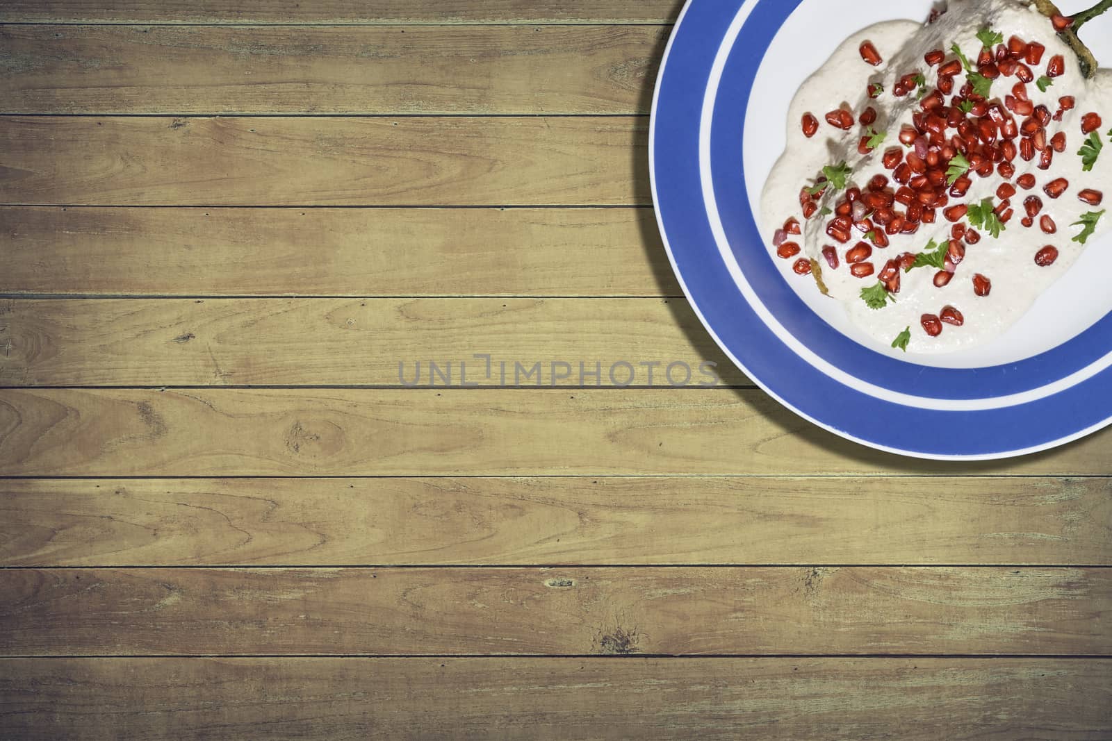 Top view of chiles en nogada, traditional festive dish on Mexican Independence Day. Green chili peppers with walnut sauce, common food for Mexico, in celebrations and national holidays by leo_de_la_garza