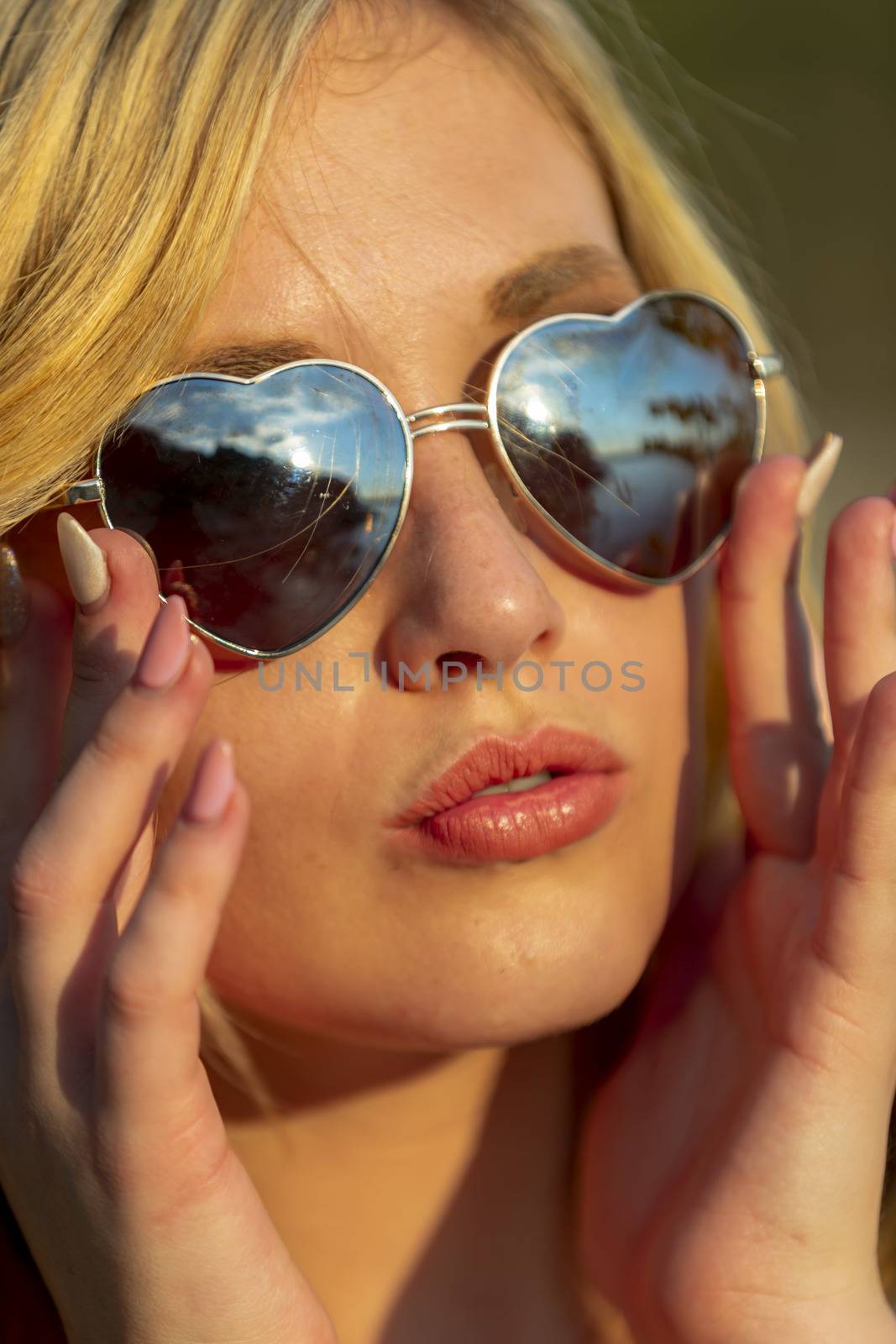 A gorgeous blonde model enjoys a summers day outdoors in a park