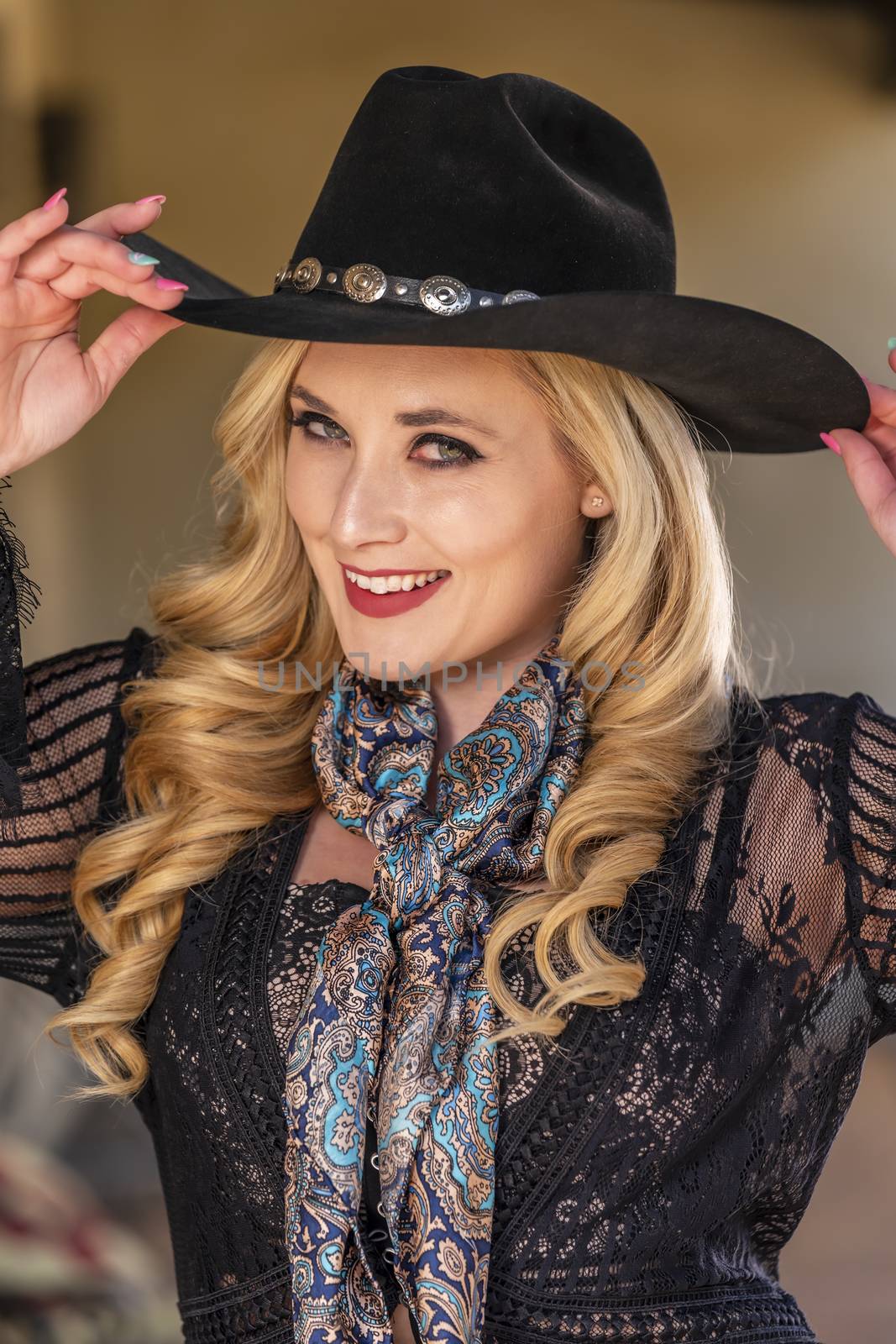 A gorgeous blonde model dressed as a cowgirl enjoying the outdoor weather