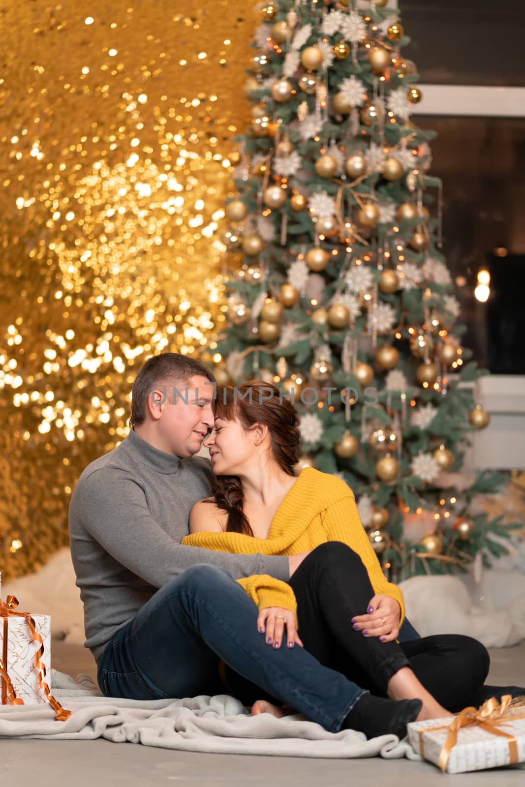 A beautiful cheerful couple greets the Christmas holidays in a cozy home atmosphere.