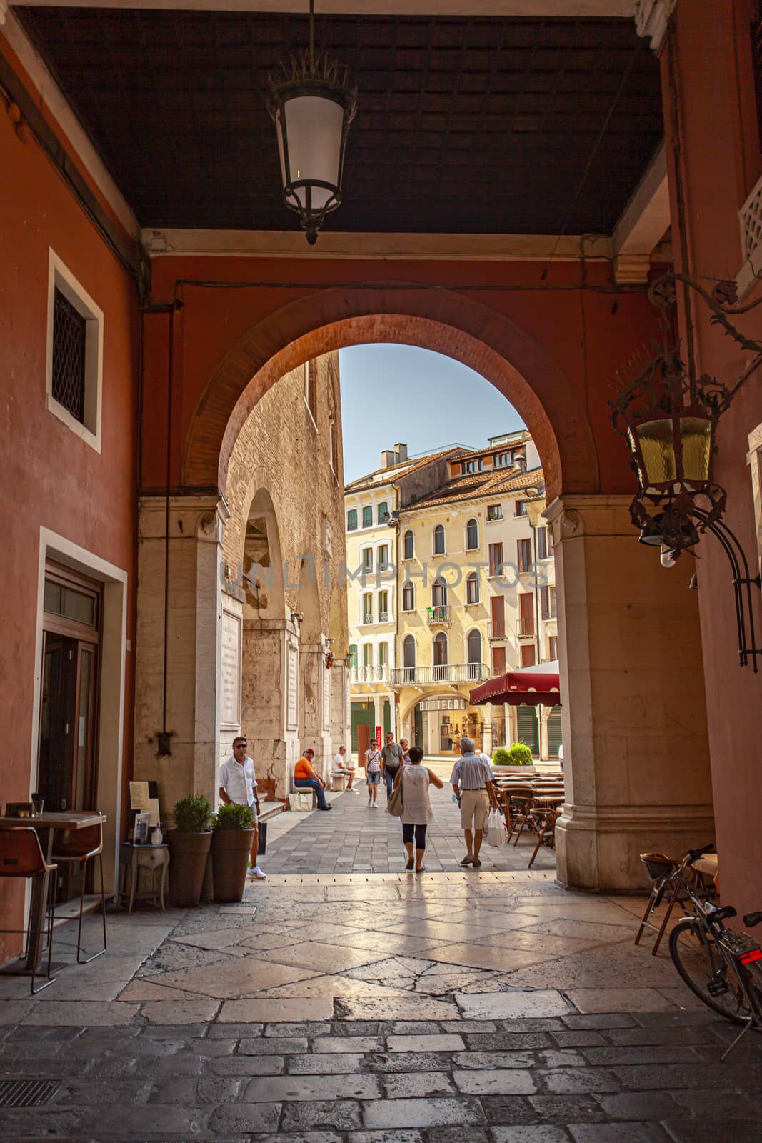 TREVISO, ITALY 13 AUGUST 2020: Arcades in Piazza dei signori in Treviso with people passing through