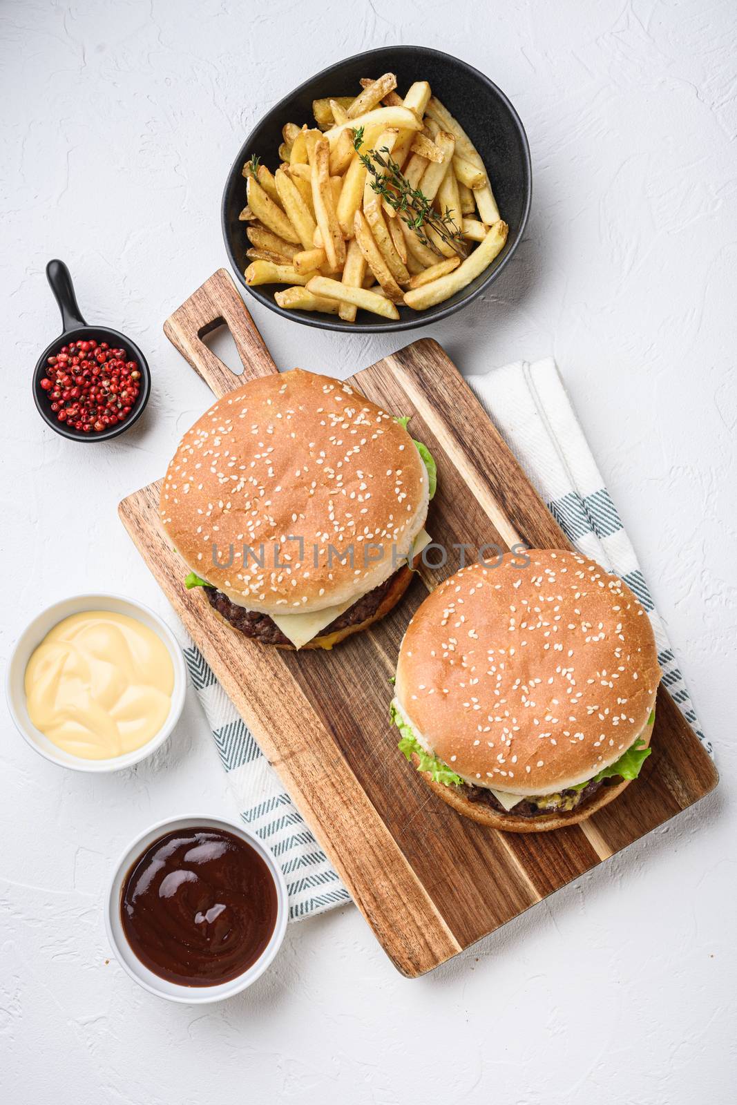 Two ground beef burger and french fries on white textured background by Ilianesolenyi