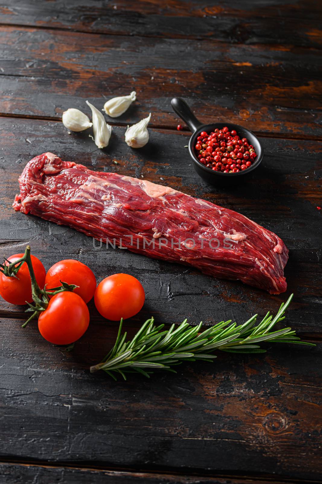 Machete steak raw cut or hanging tende cut, with rosemary over wood background Top side view.