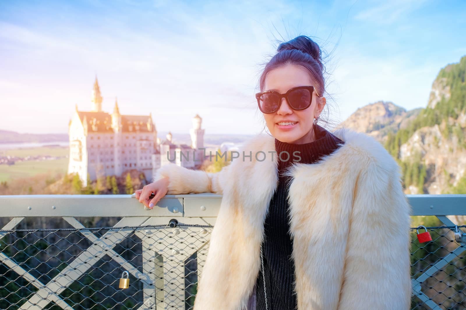 Young Beautiful Woman Tourists in Queen Mary's Bridge near the Neuschwanstein Castle at daylight in Germany