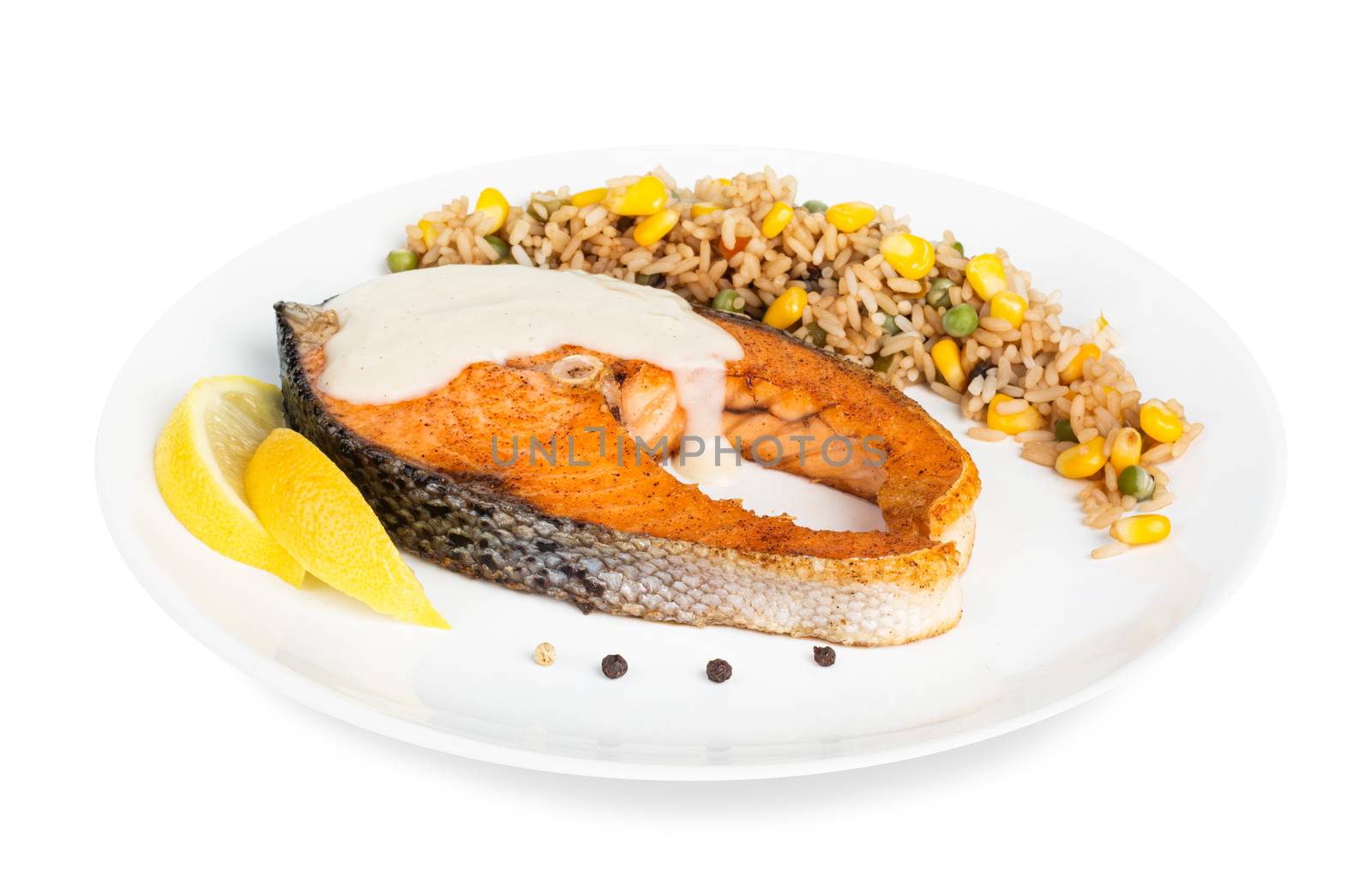 Fried cooked salmon with garnish of rice and vegetables on white plate isolated on white background
