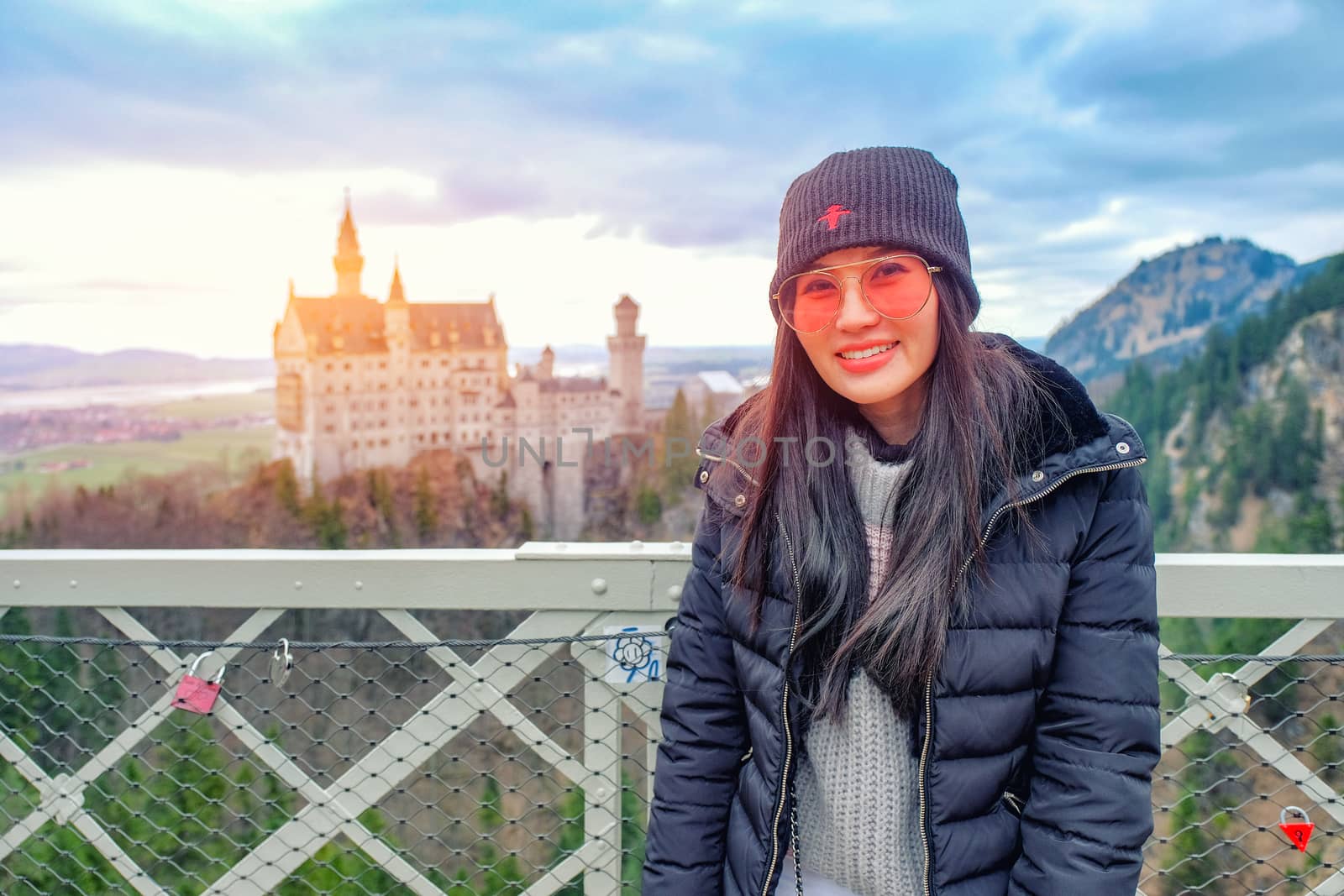 Young Beautiful Woman Tourists in Queen Mary's Bridge near the Neuschwanstein Castle at daylight in Germany