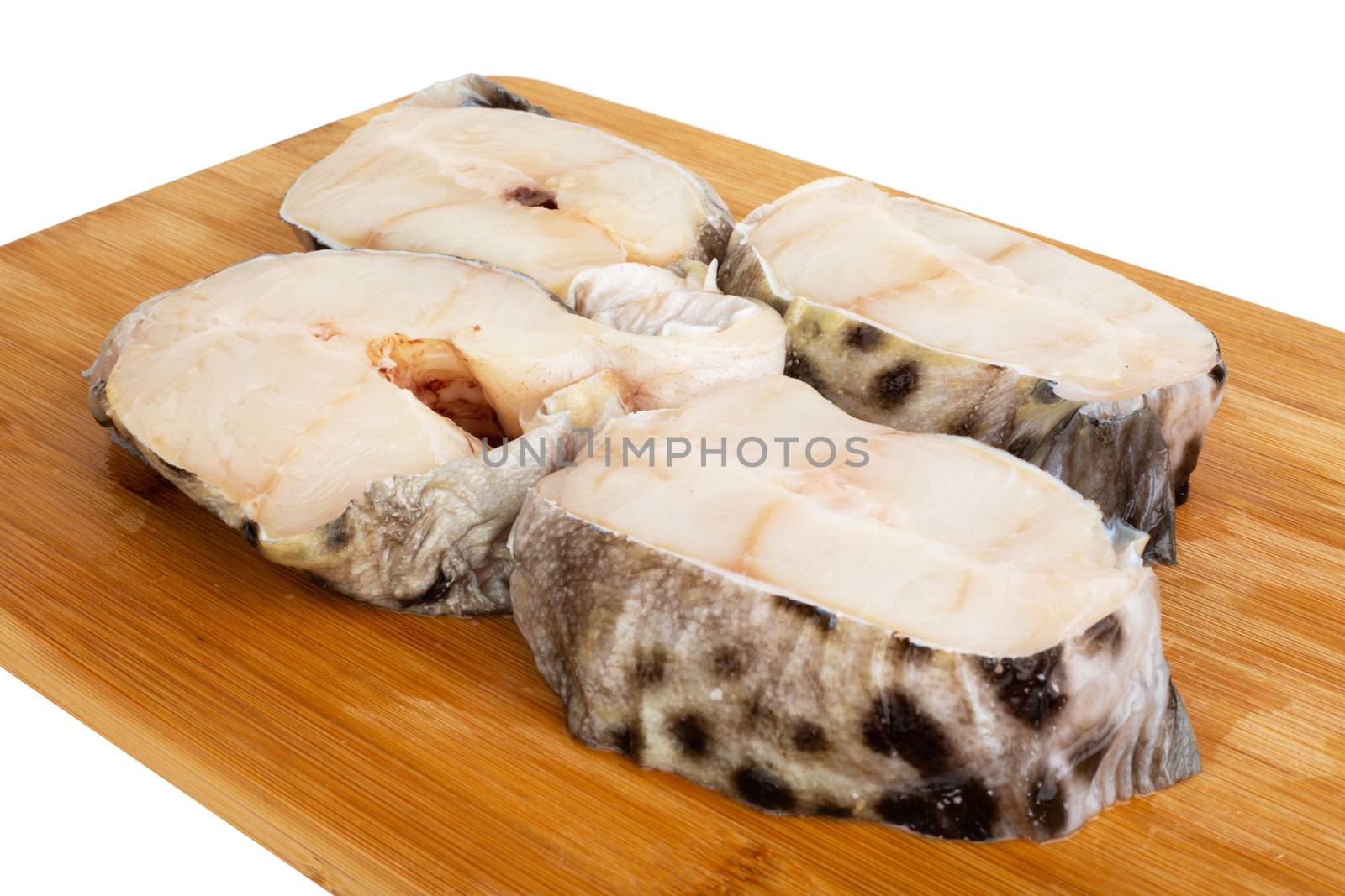 Raw catfish fish steaks on wooden cutting board studio isolated on white background
