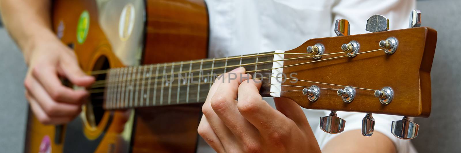 Young boy playing guitar. Close-up of man hand playing classic guitar. teenager learning playing guitar