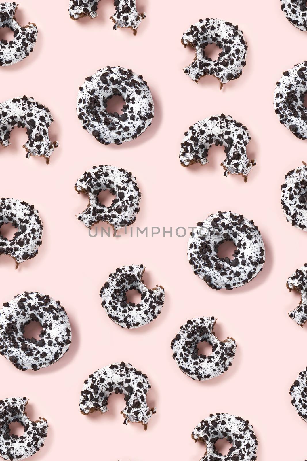 donuts on a pink background top view. Flat lay of delicious nibbled chocolate donuts. used as donut banner or poster background, not pattern