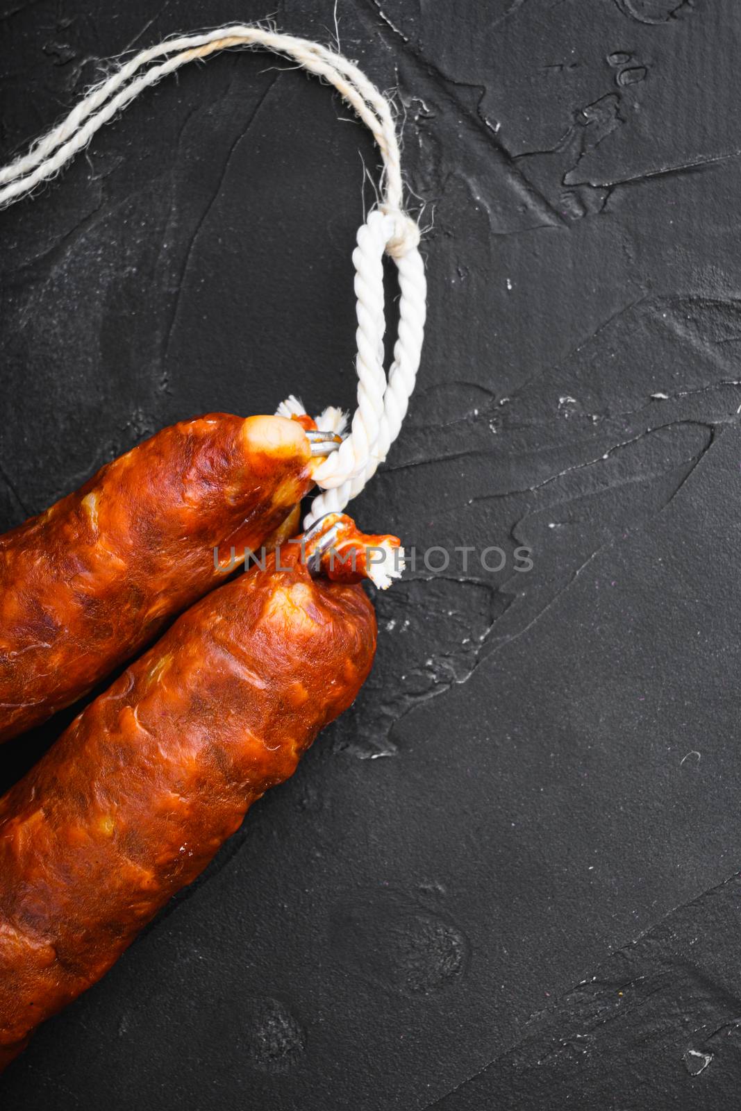 Spanish pork chorizo sausages on black textured background with copy space.