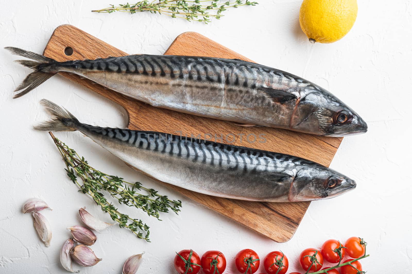 Two whole mackerel with ingredients on white textured background, flat lay.