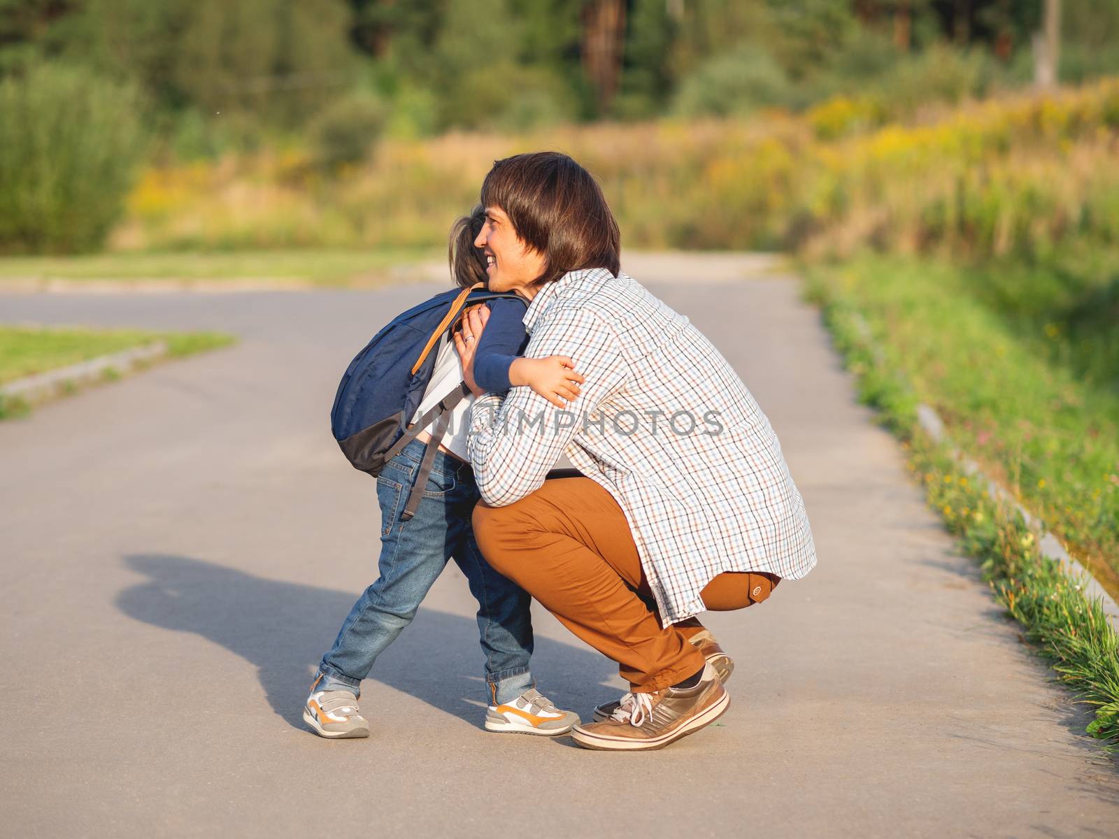 Father takes his son to school. Back to school after summer holidays. Dad and kid hugs on street. Emotional or moral support.