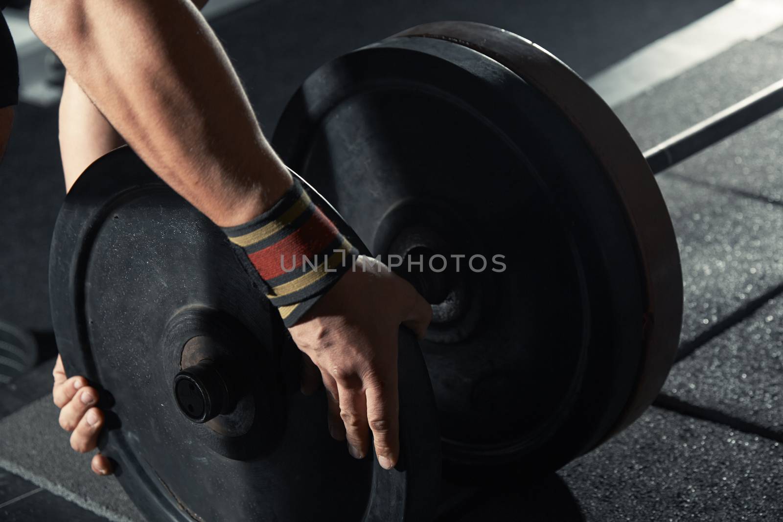 Man preparing barbell at fitness club