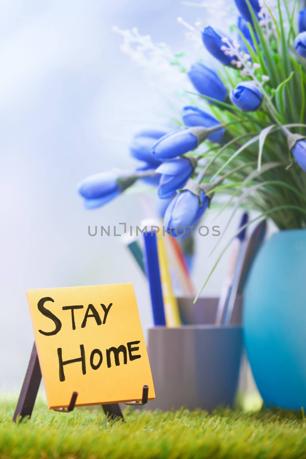 Adhesive note with Stay Home text at the green office by Novic