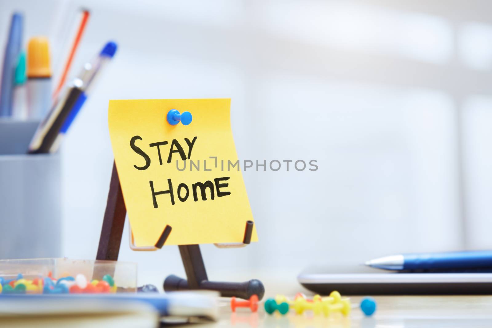 Stay Home text on adhesive note at the office by Novic