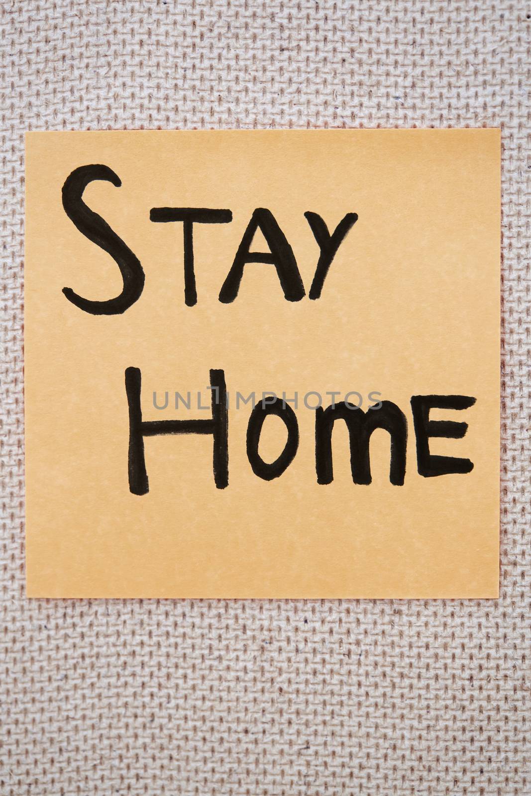 Adhesive note with Stay Home text on a bulletin board