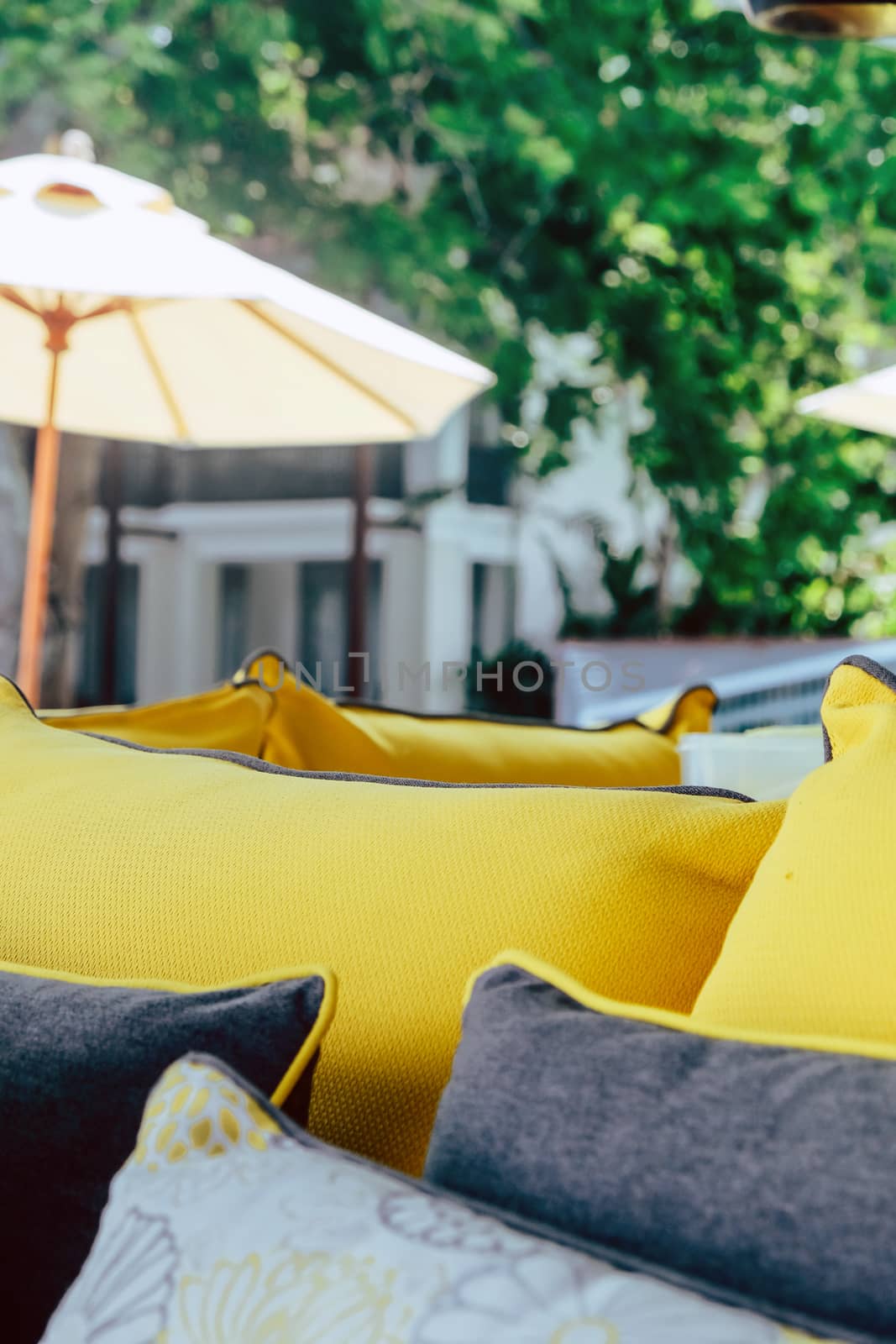 Close up of yellow fabric sofa and cushions decorate in tropical resort by ponsulak