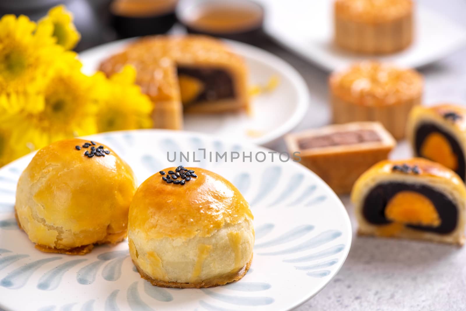 Tasty baked egg yolk pastry moon cake for Mid-Autumn Festival on bright cement table background. Chinese traditional food concept, close up, copy space.